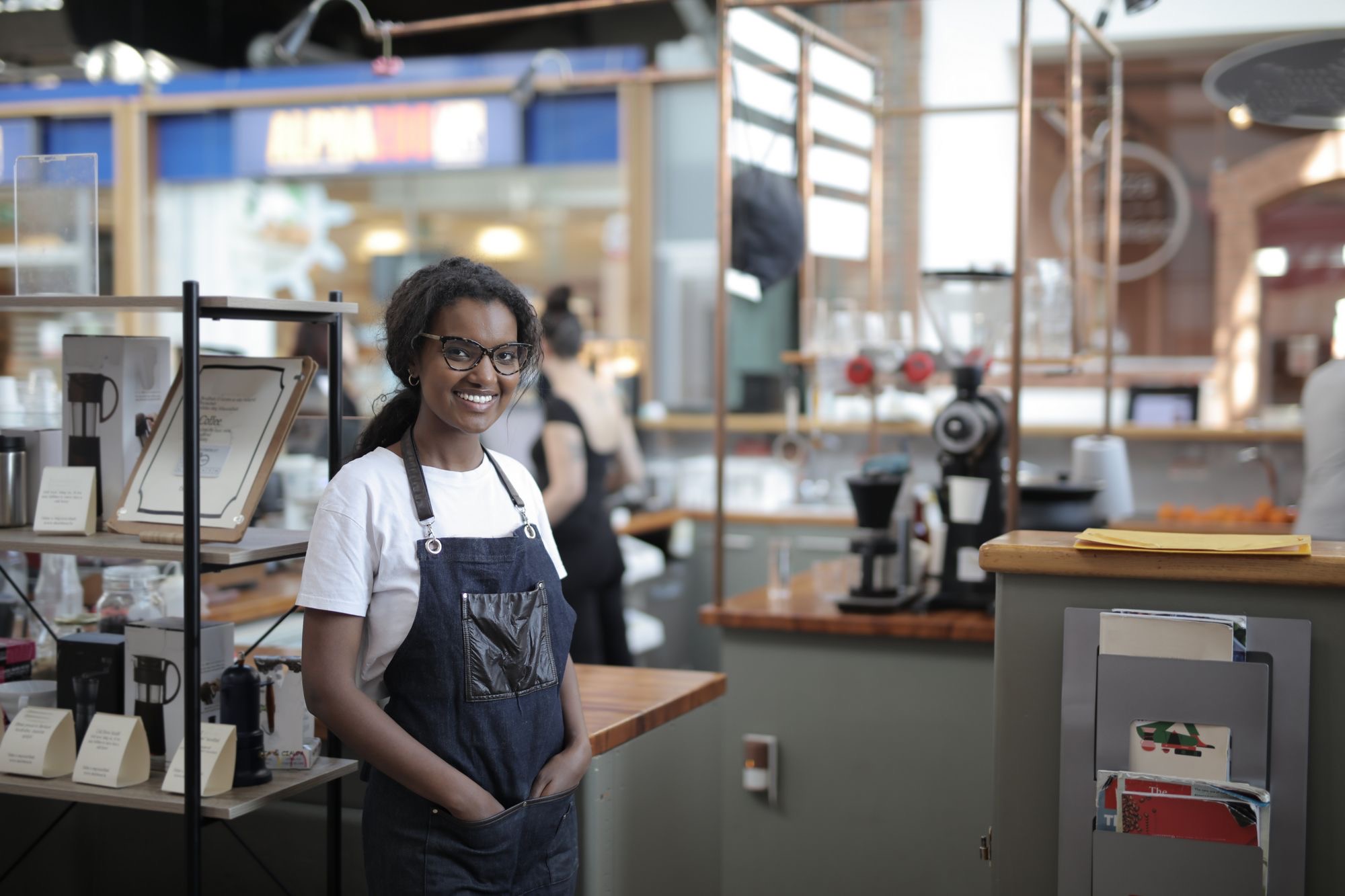 A café owner working the counter behind a spread of fresh food